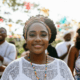 A black woman in the Black Wall Street Festival with the people in the event having fun and enjoying the event