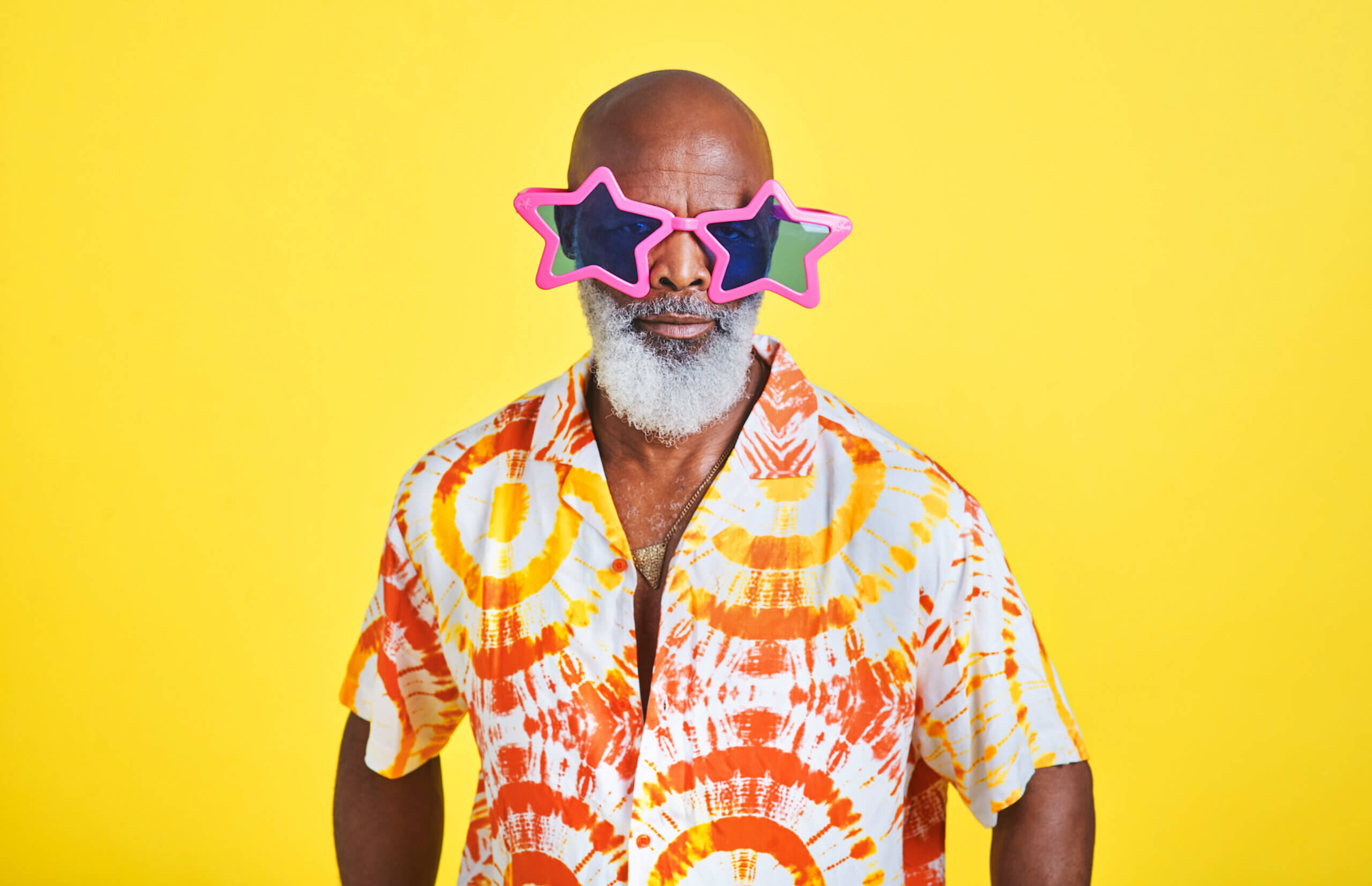 Mature man, sunglasses and funky on studio background for birthday party, happiness and festival. Black person, celebration and cool trendy eyewear for holiday, event and New Year concert with relax. And celebrating 65th birthday and eligible for Medicare and Medicare Advantage