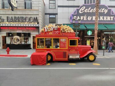 Food truck selling popcorn in the street near a cinema