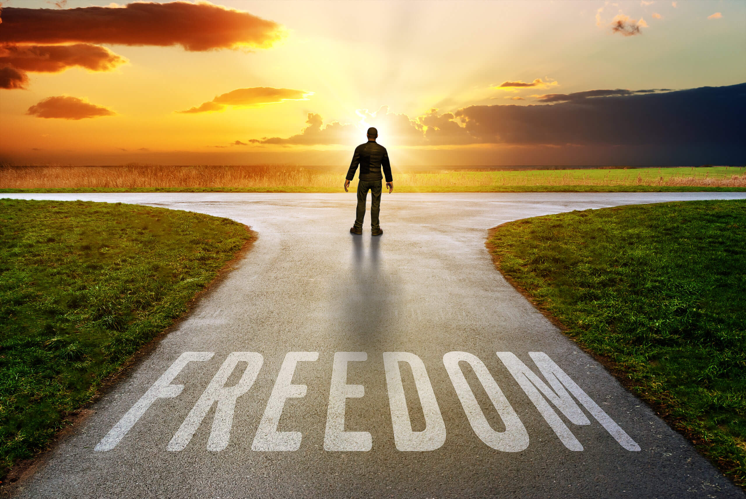 Freedom lettering on a path towards a beautiful sunset on the horizon