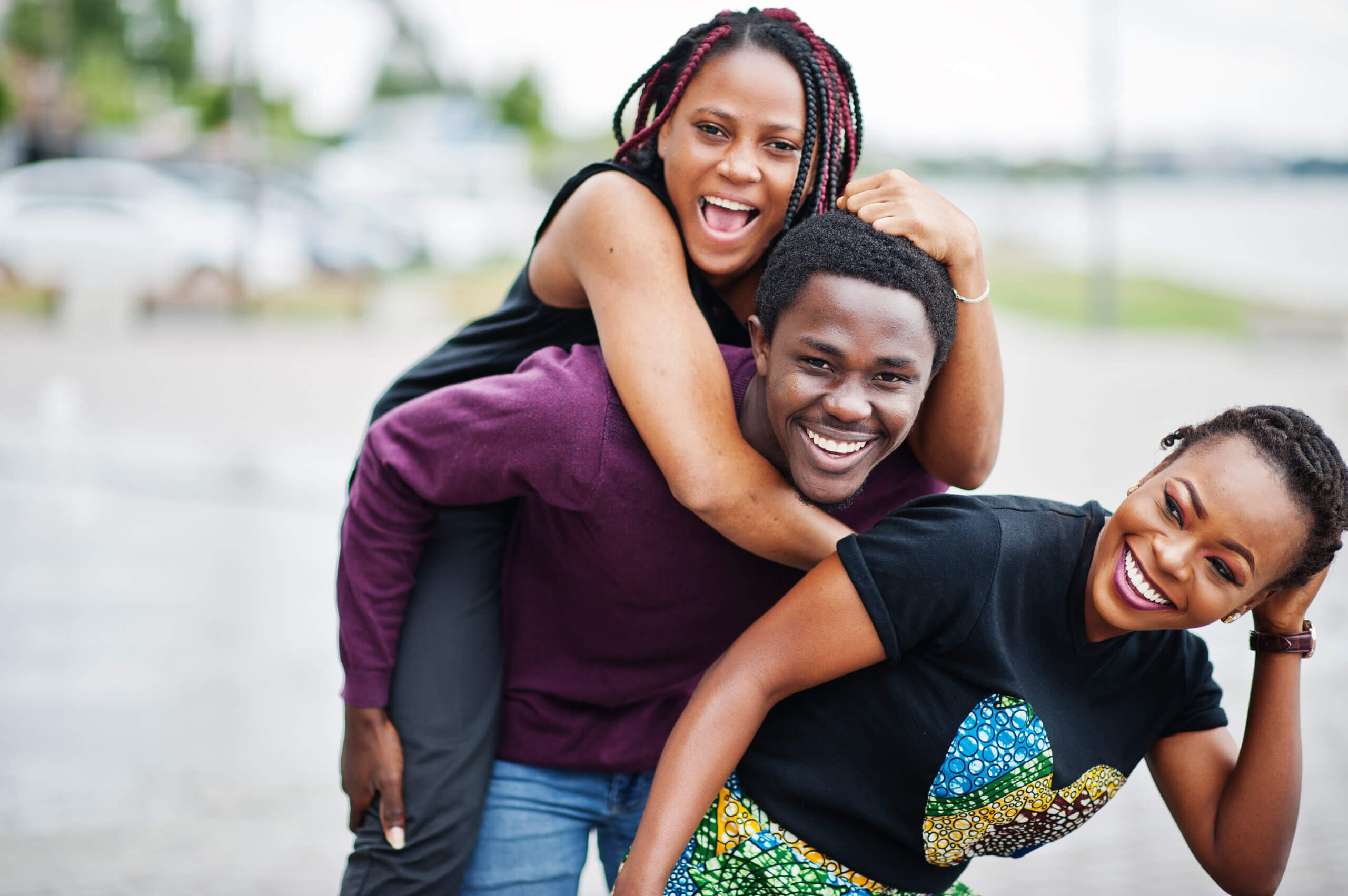Three african american friends having fun together. Jump on shoulder. Happy with insurance