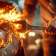 A mechanic holding a wrench in a flaming car, caring with Commercial Auto Insurance