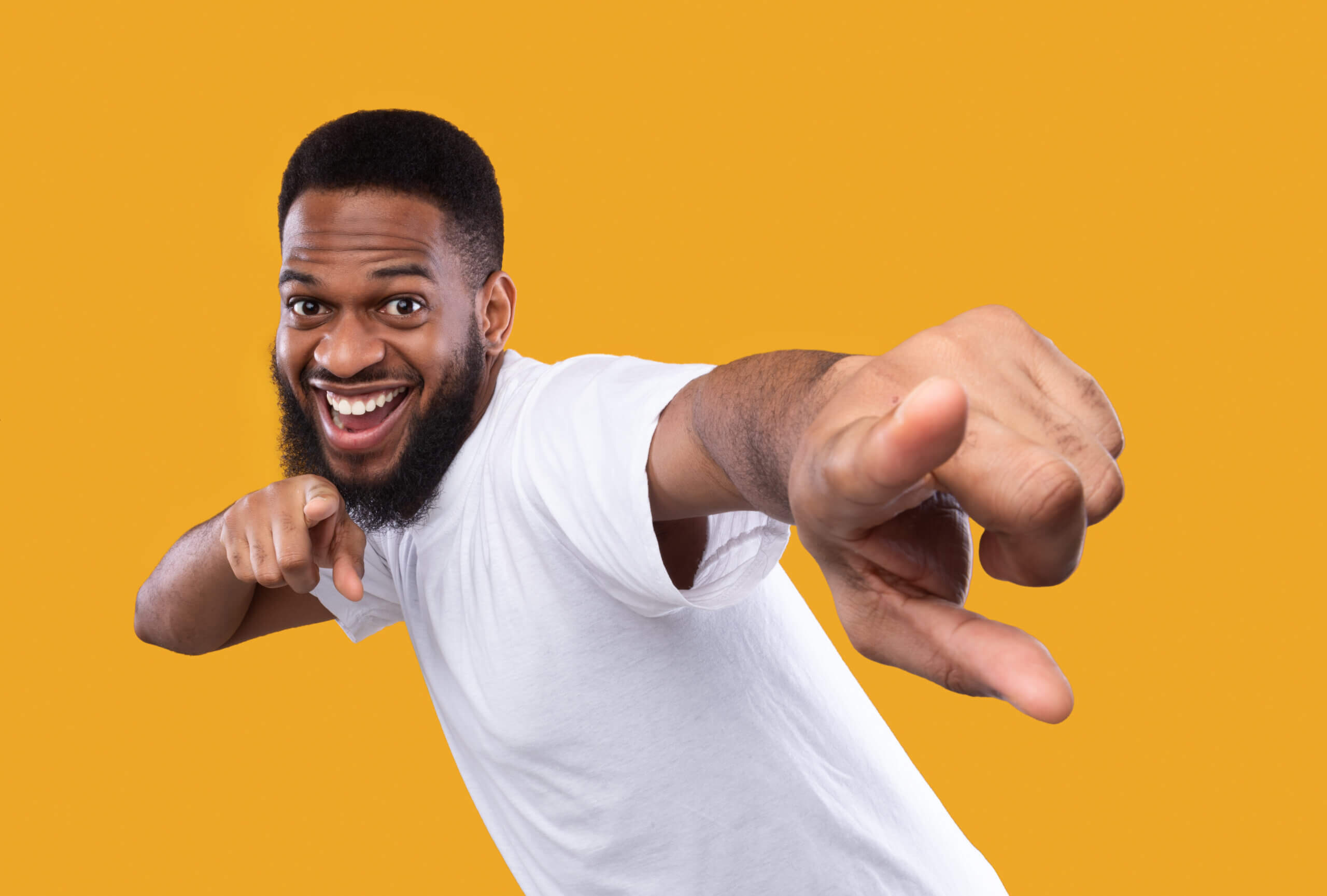You're next. Funny african man pointing fingers at camera posing in studio on yellow background. I choose you concept, advertisement banner with cheerful black guy