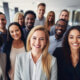 Diverse group of employees project team standing together in modern business building - group selfi portrait of cheerful and joyful young and senior employees colleagues